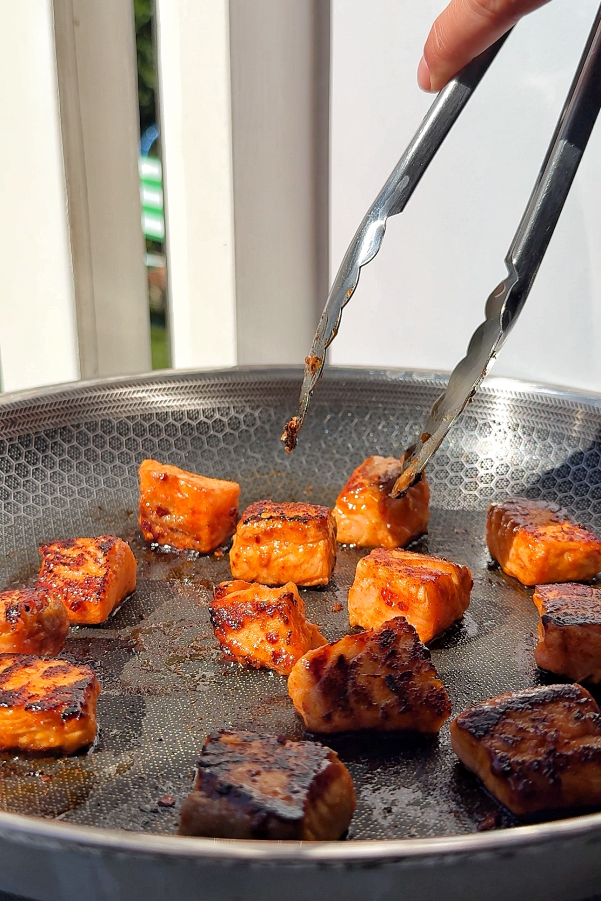 Frying salmon bites in a pan.