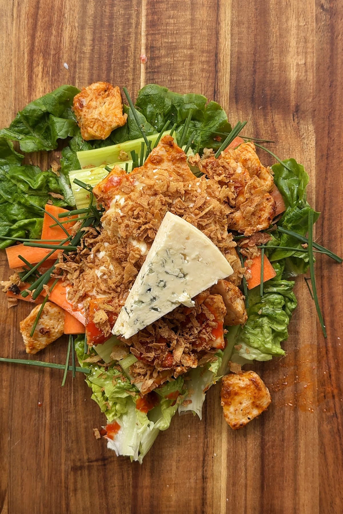 Chopping board with buffalo chicken wrap ingredients.