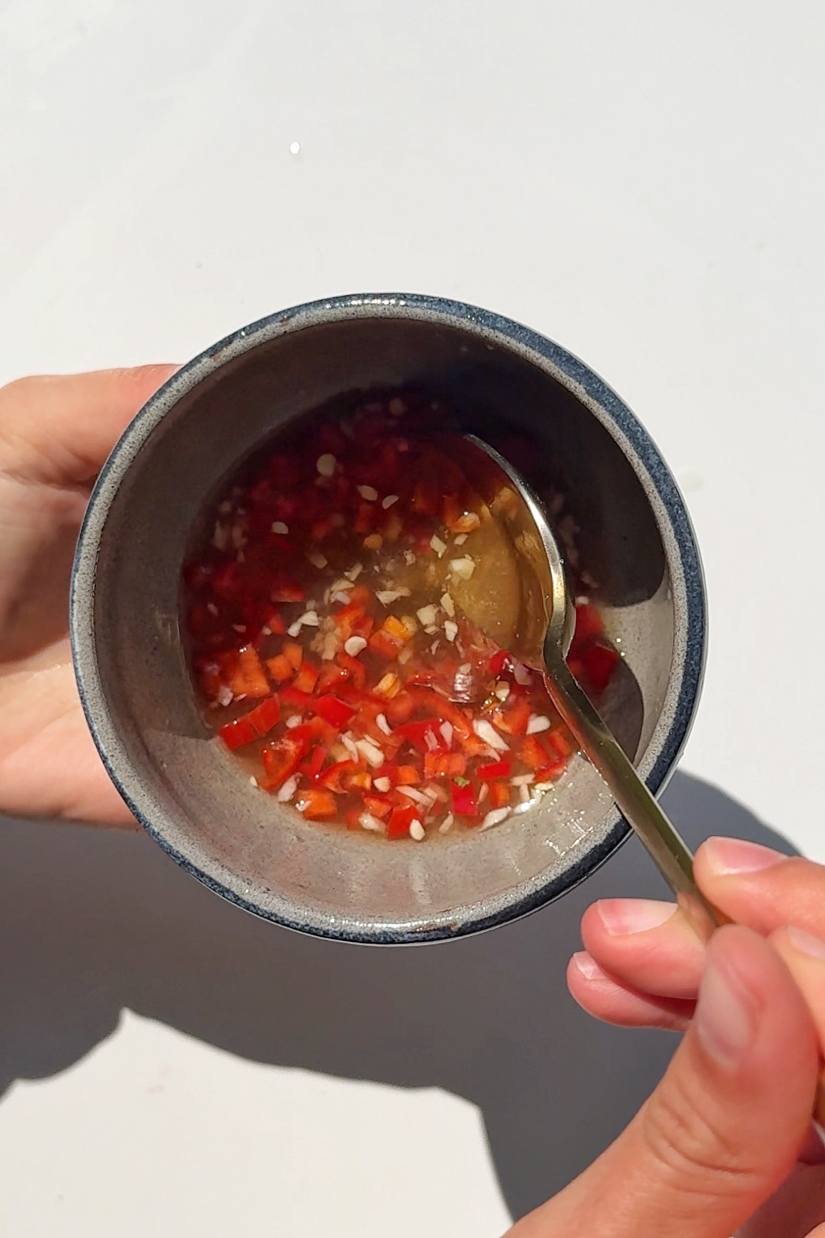 Making nuoc Cham sauce in blue bowl.