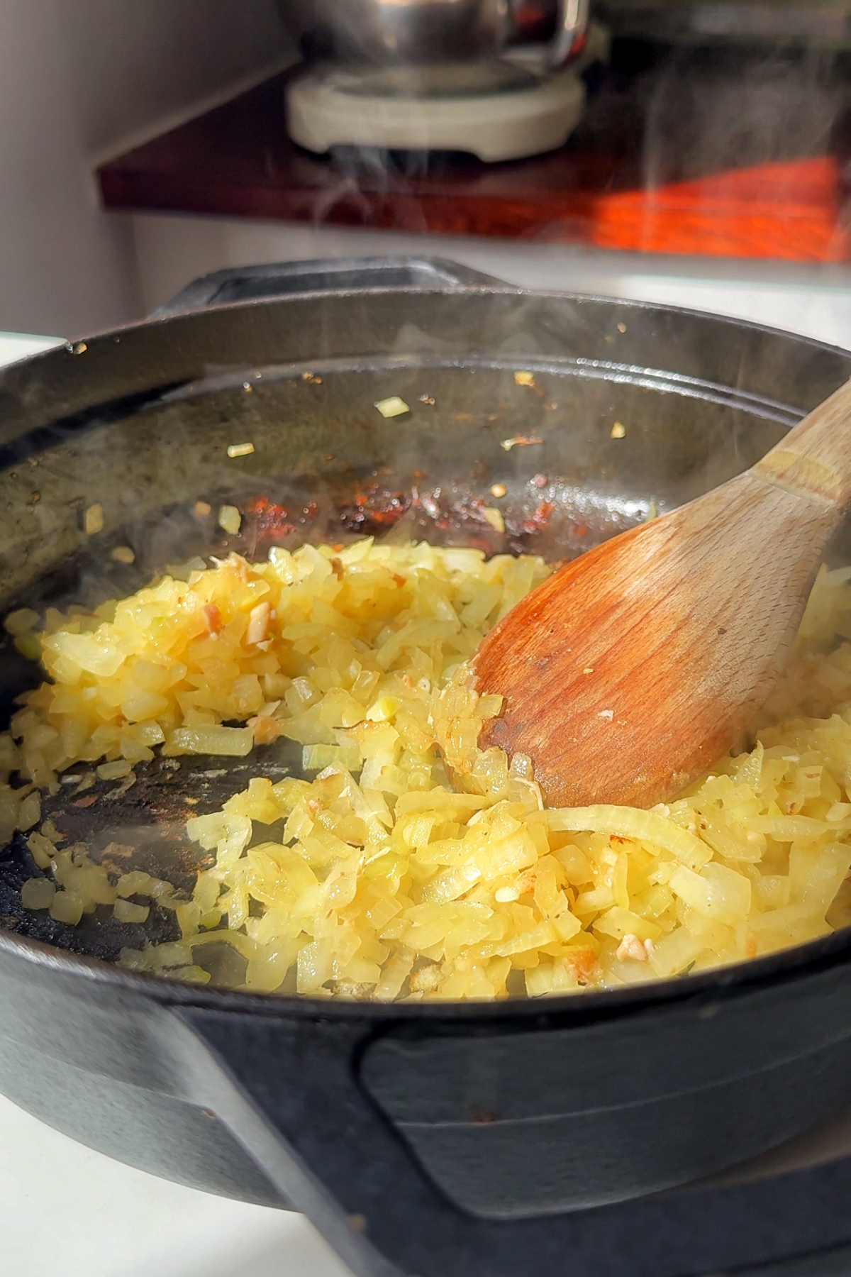 Frying garlic and onion in a large black pan.