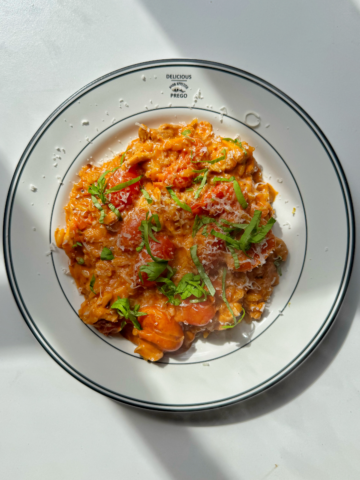 Creamy tomato orzo on a white plate.