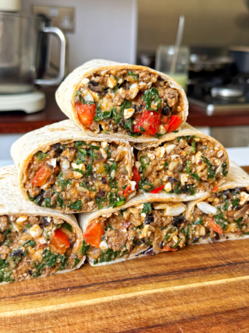high protein breakfast burritos stacked on top of each other.