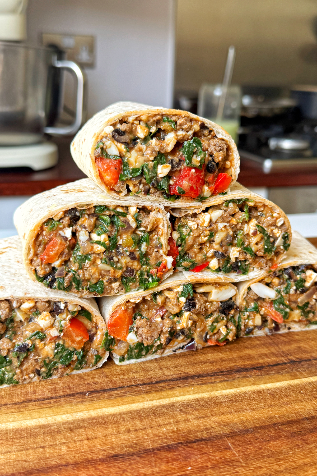 high protein breakfast burritos stacked on top of each other.