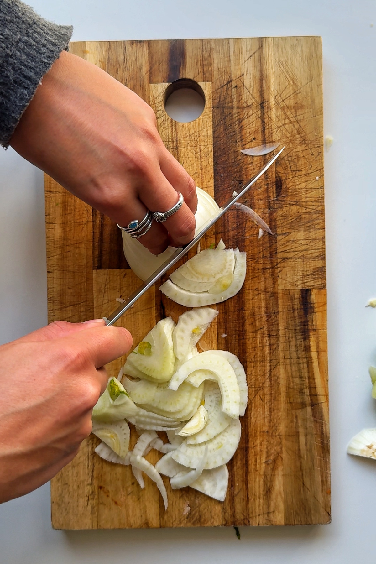 Slicing fennel on a wooden board.