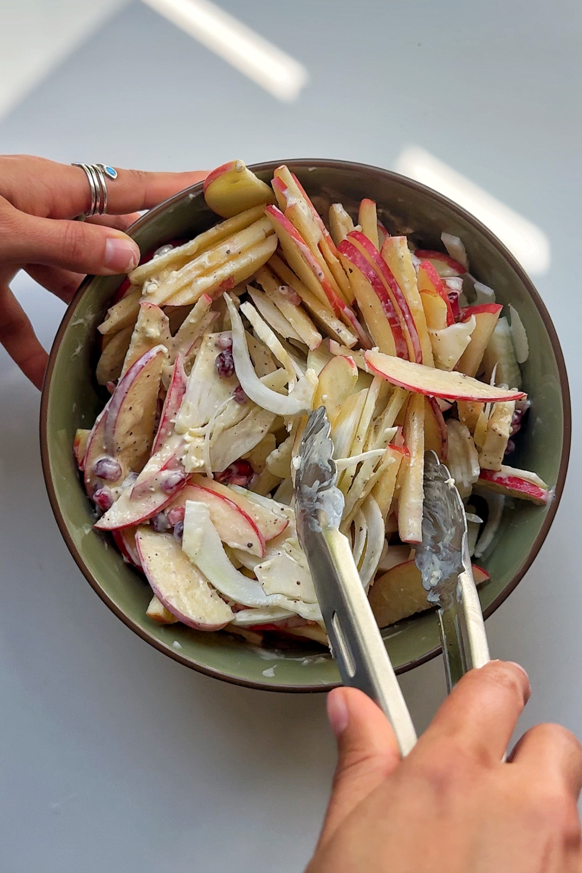 Tossing the apple fennel salad in a big bowl.