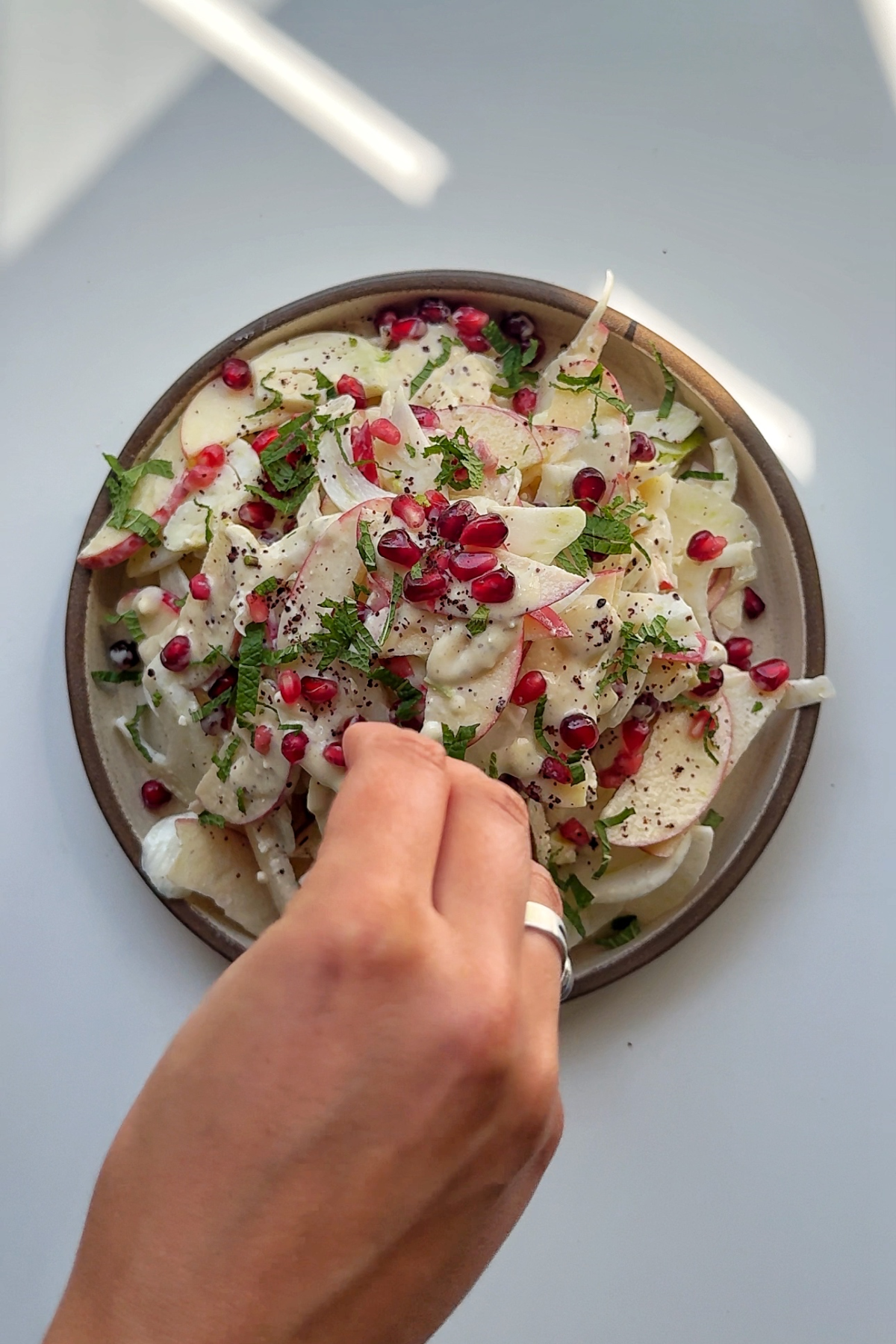 Garnishing the fennel apple salad with mint.