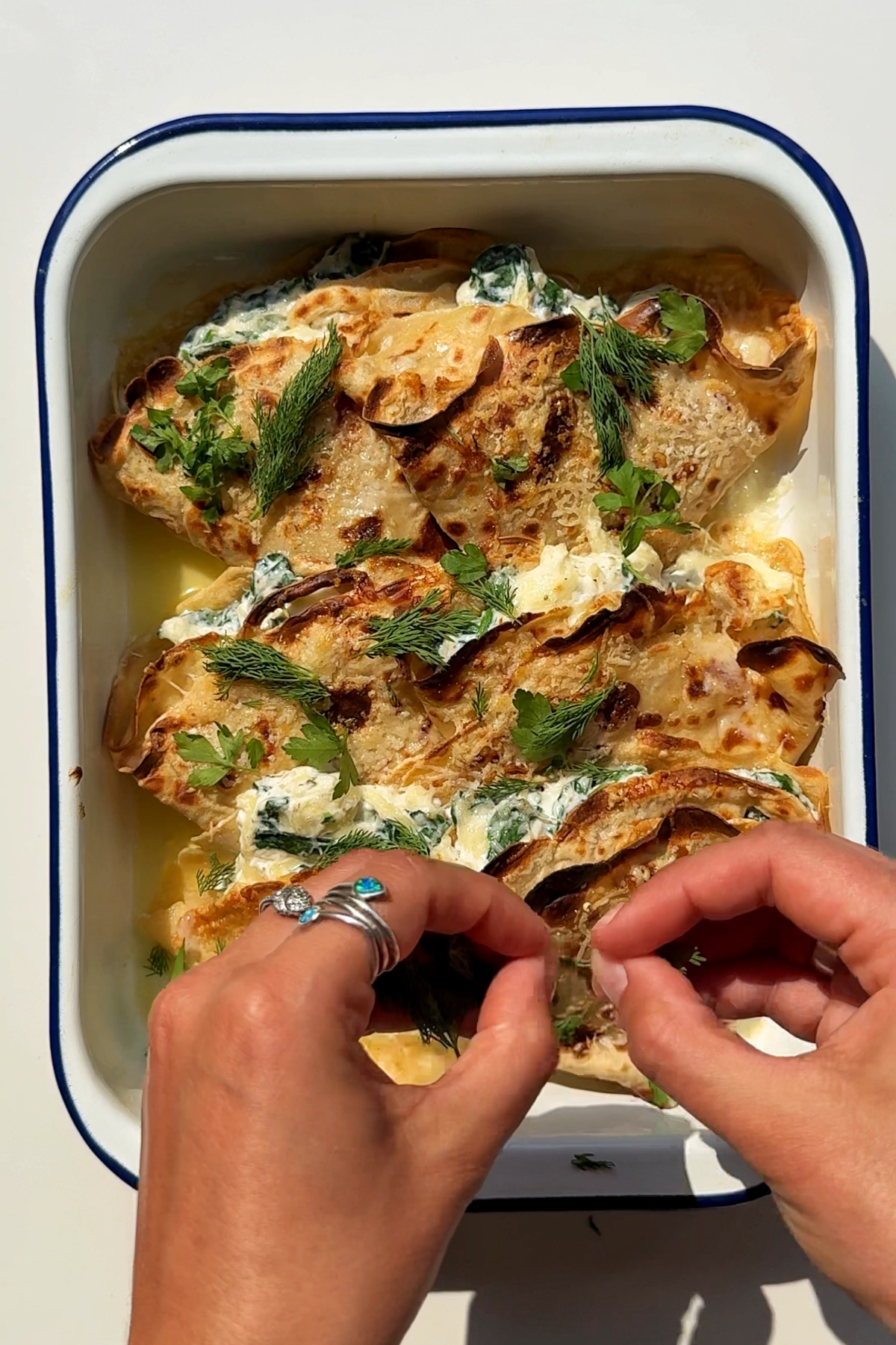 Sprinkling herbs onto the crespelle.