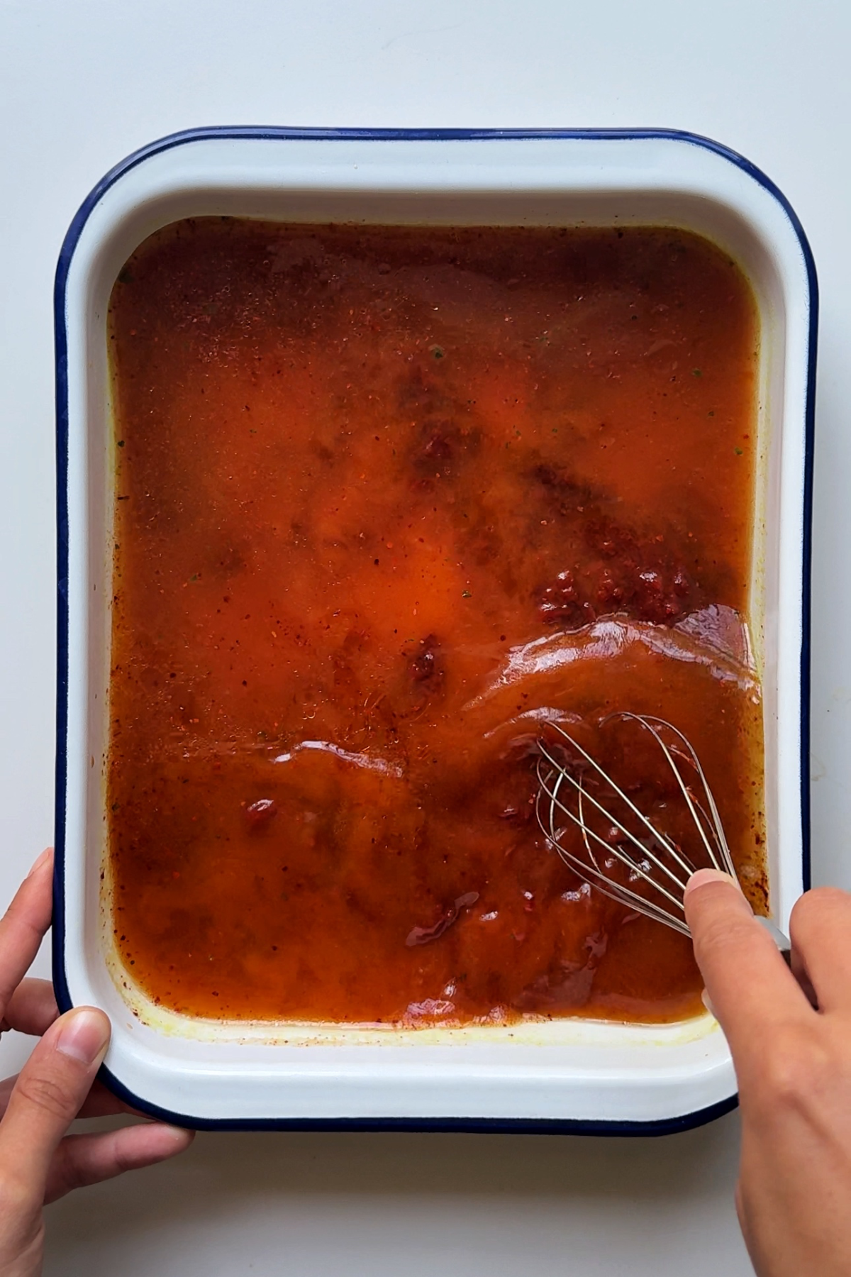 Creating the gochujang mixture in the base of a baking tray.