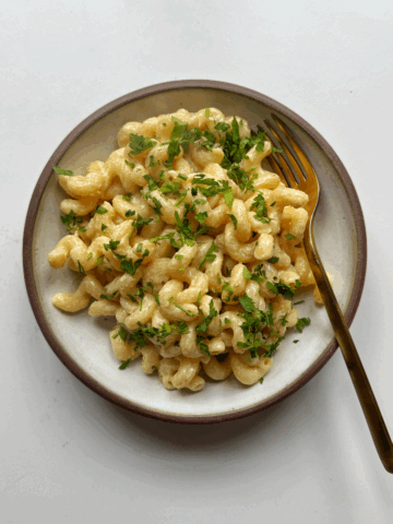Tahini pasta in white bowl with fork.