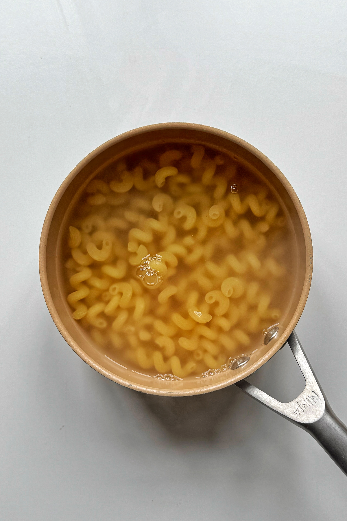 Boiling pasta in water in a pan.