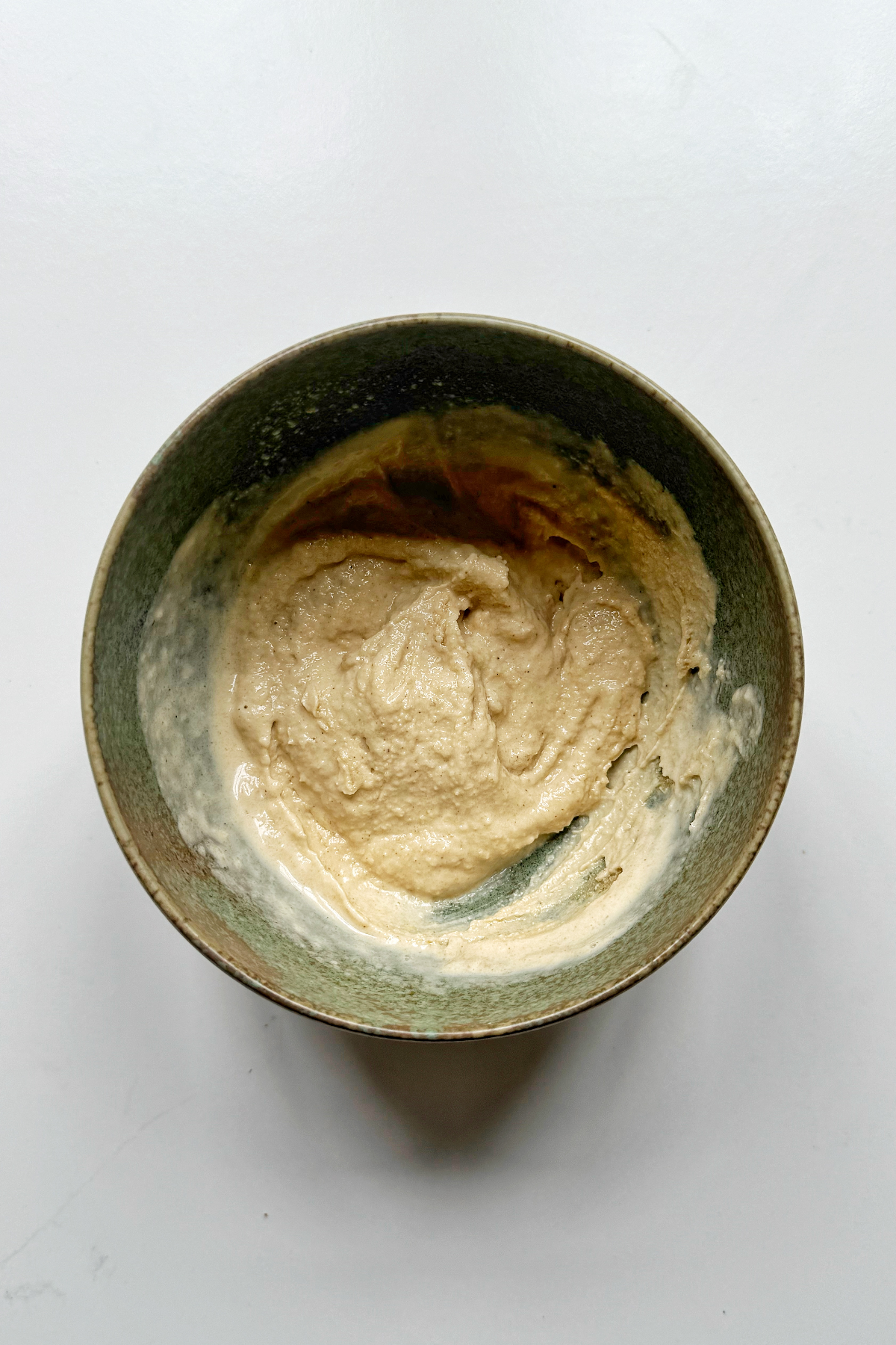 Combining the tahini pasta sauce in a bowl.