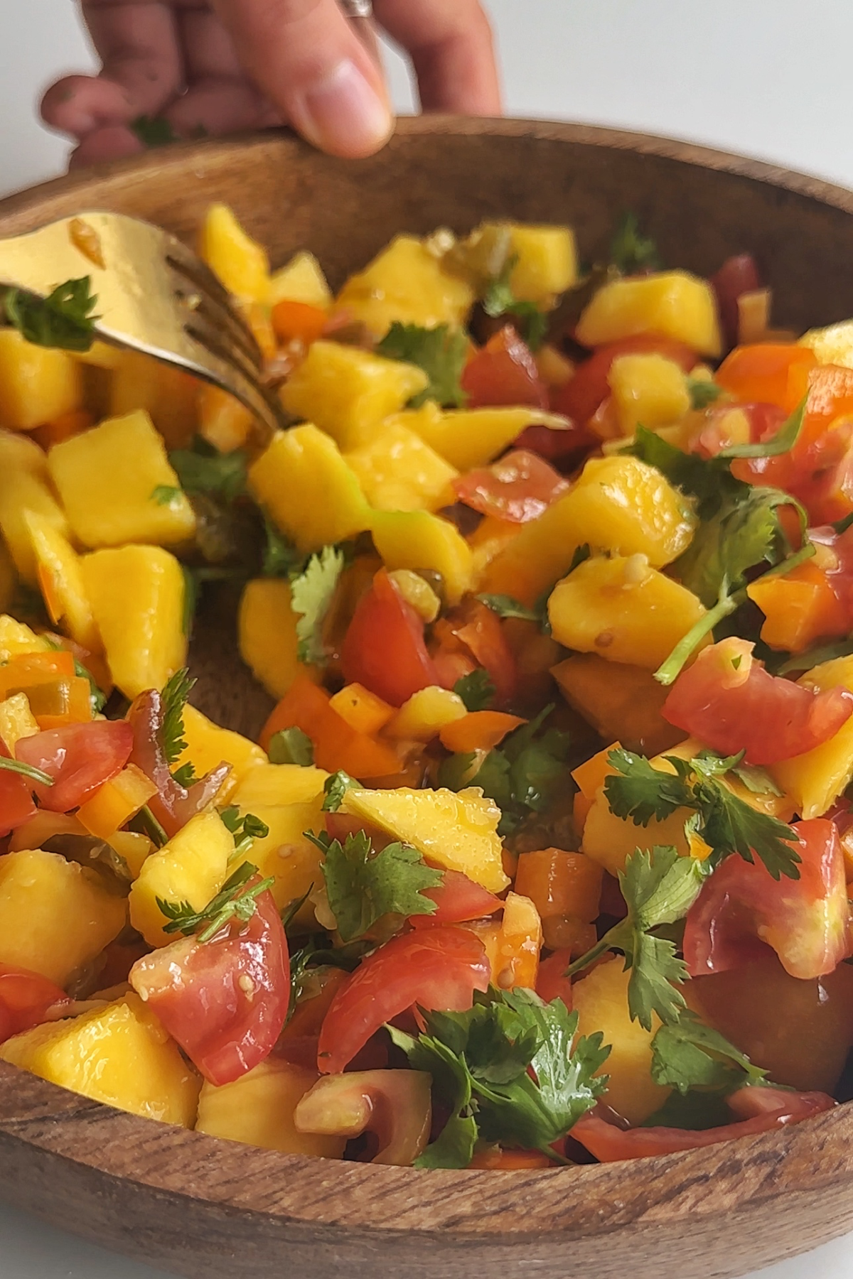 A wooden bowl of mango salsa.