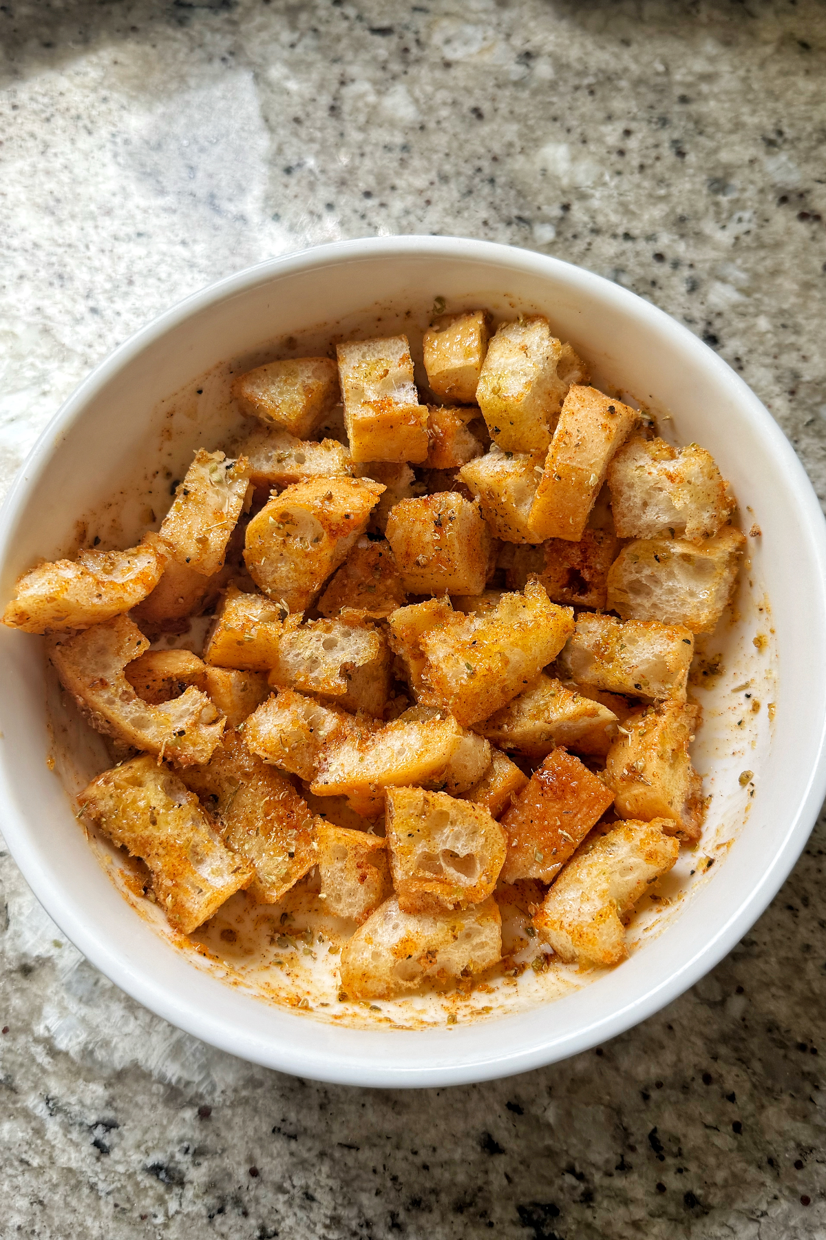 ciabatta croutons tossed in olive oil and parmesan seasoning in white bowl