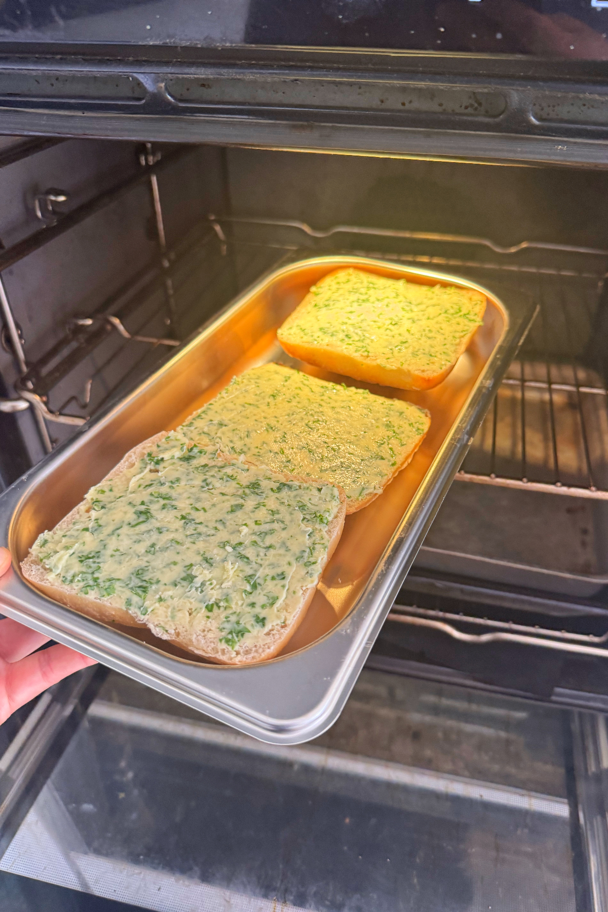 Placing the ciabatta garlic bread in the oven.
