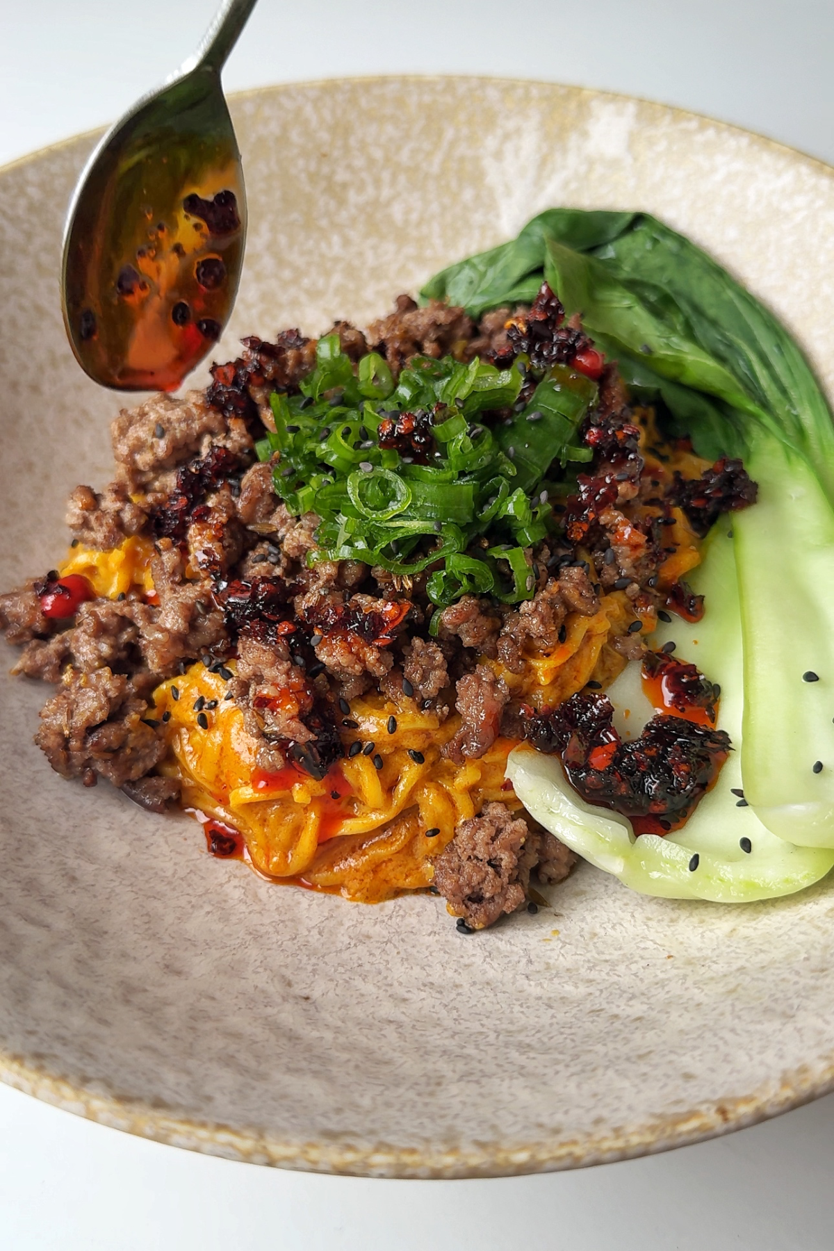 bowl of noodles with crispy ground beef and pak choi.