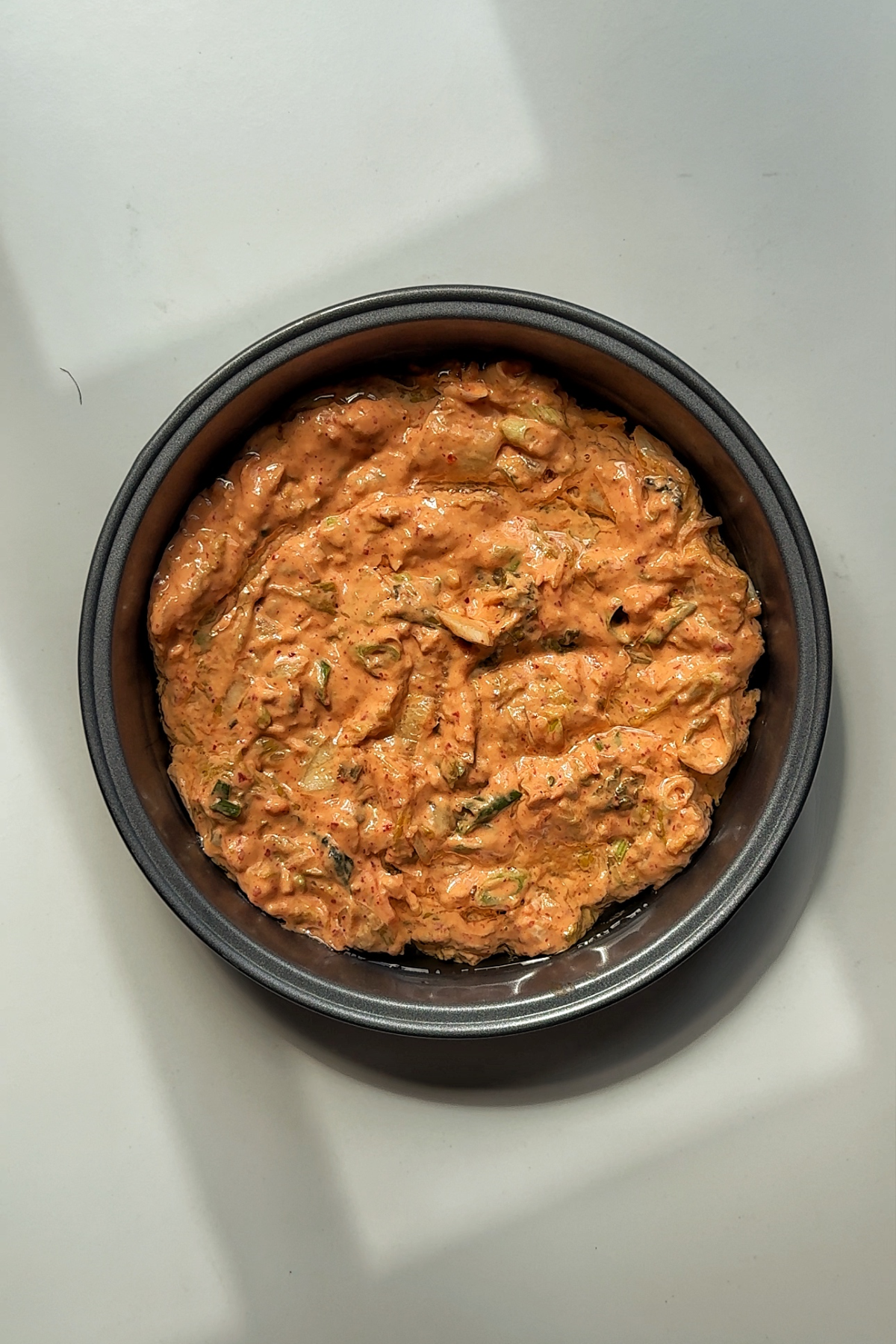 Transferring the kimchijeon batter into a cake tin.