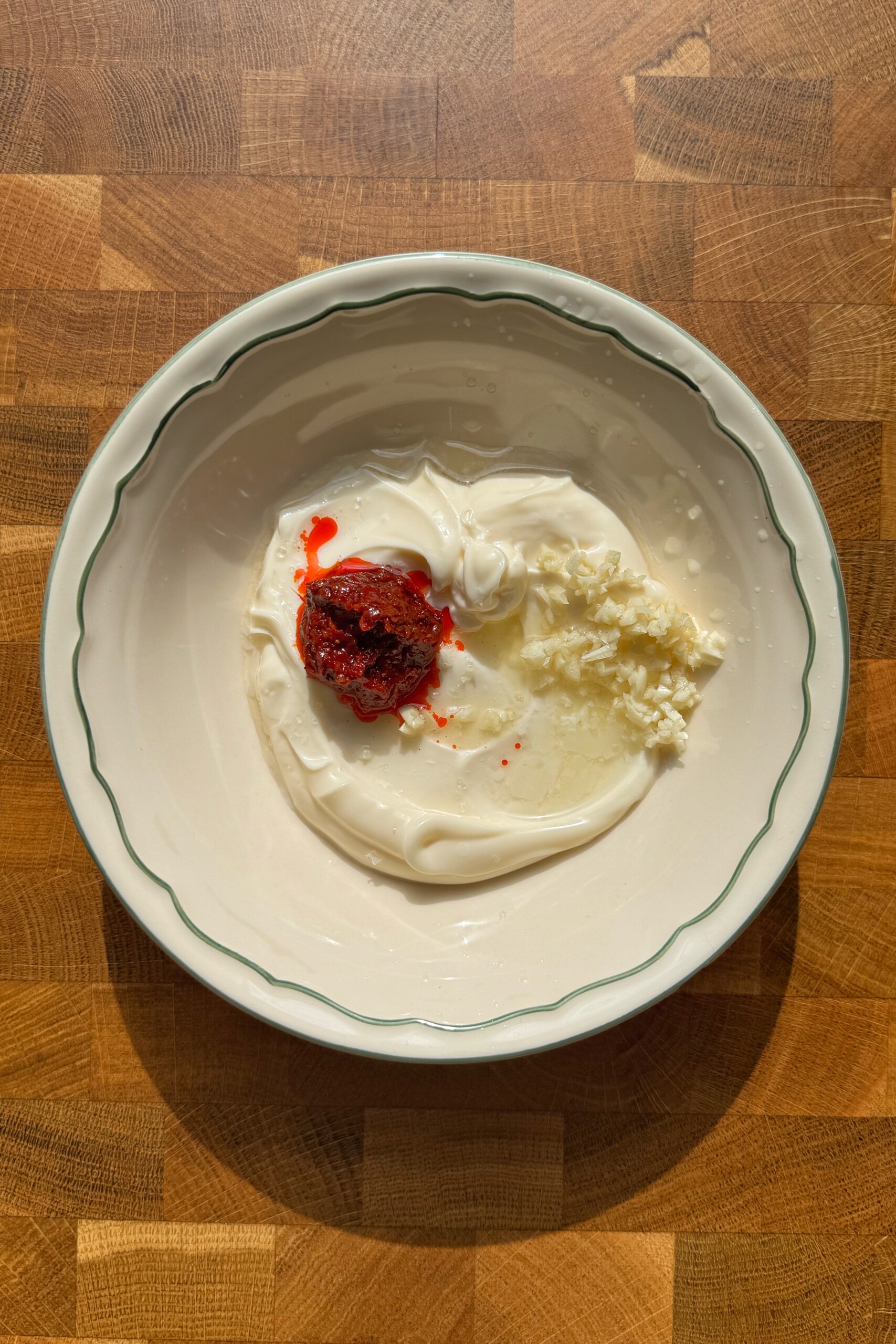 harissa aioli in white bowl before mixed.