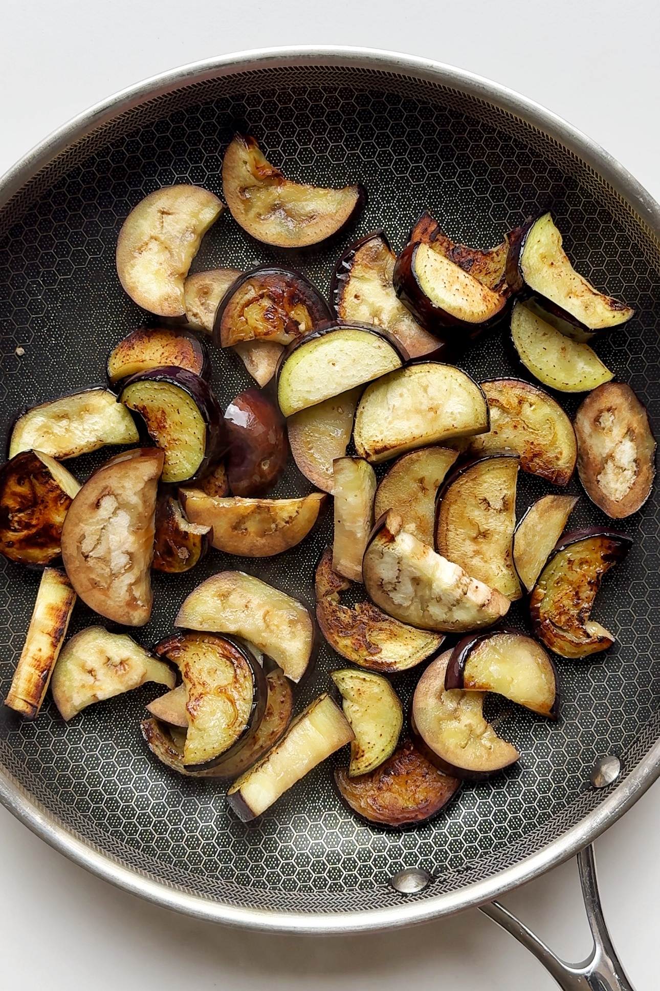 Frying aubergines in pan.