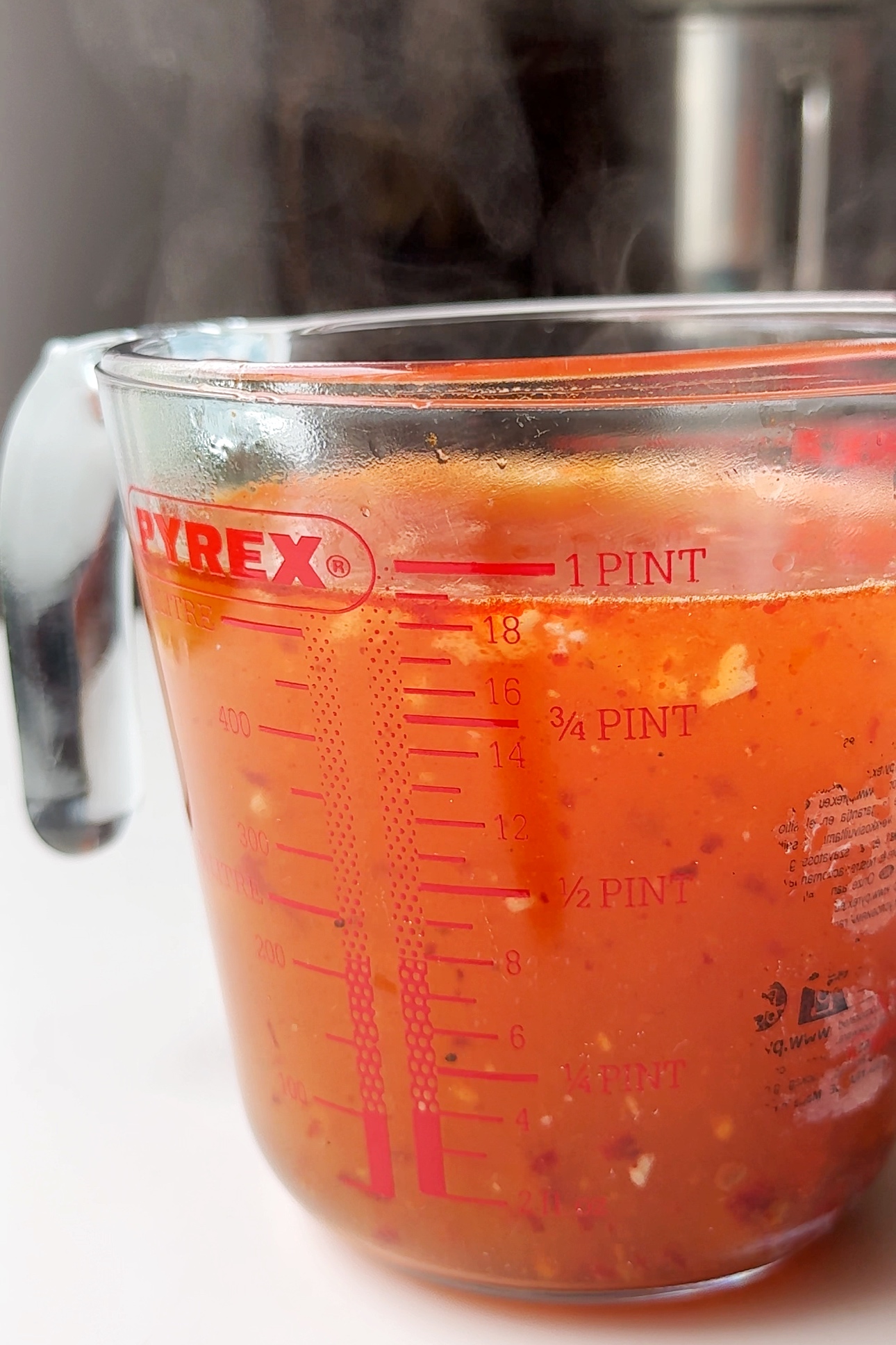 Harissa honey broth in jug.