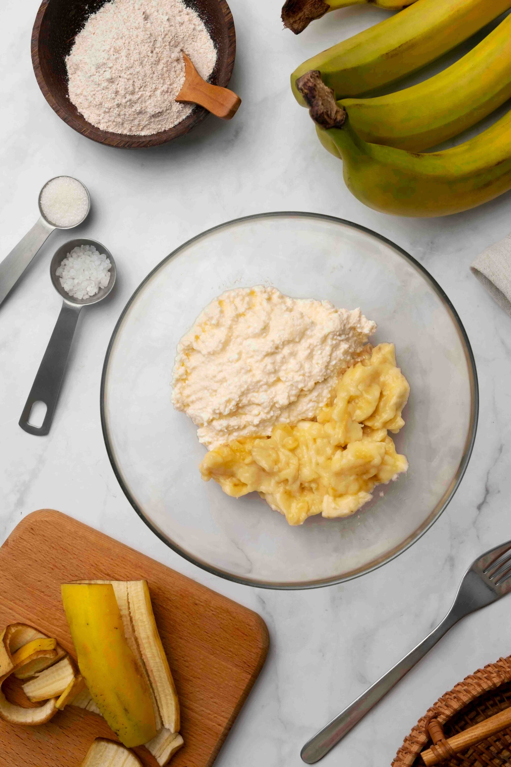 A glass bowl with mashed banana in.