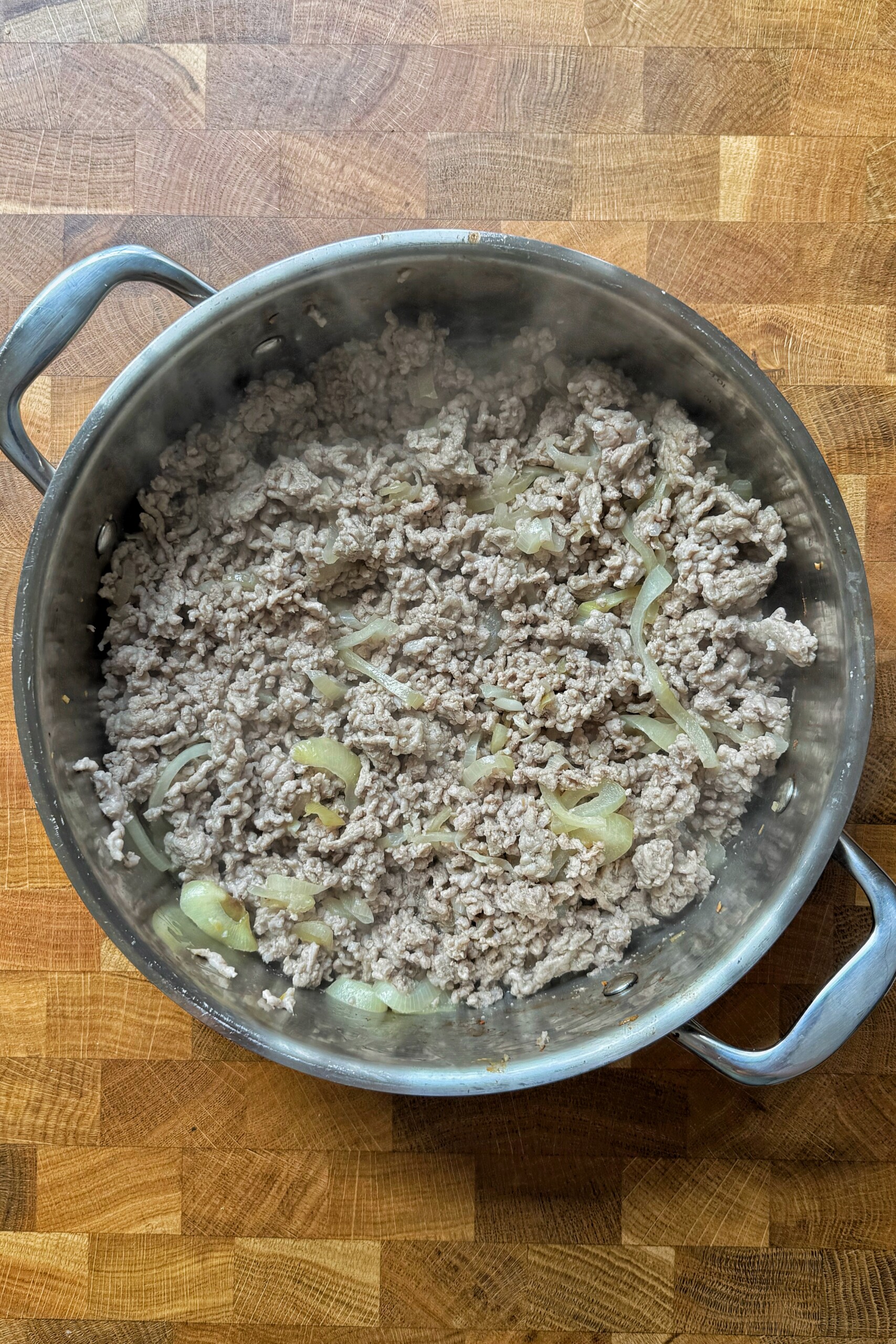 Frying ground turkey in a metal pan.