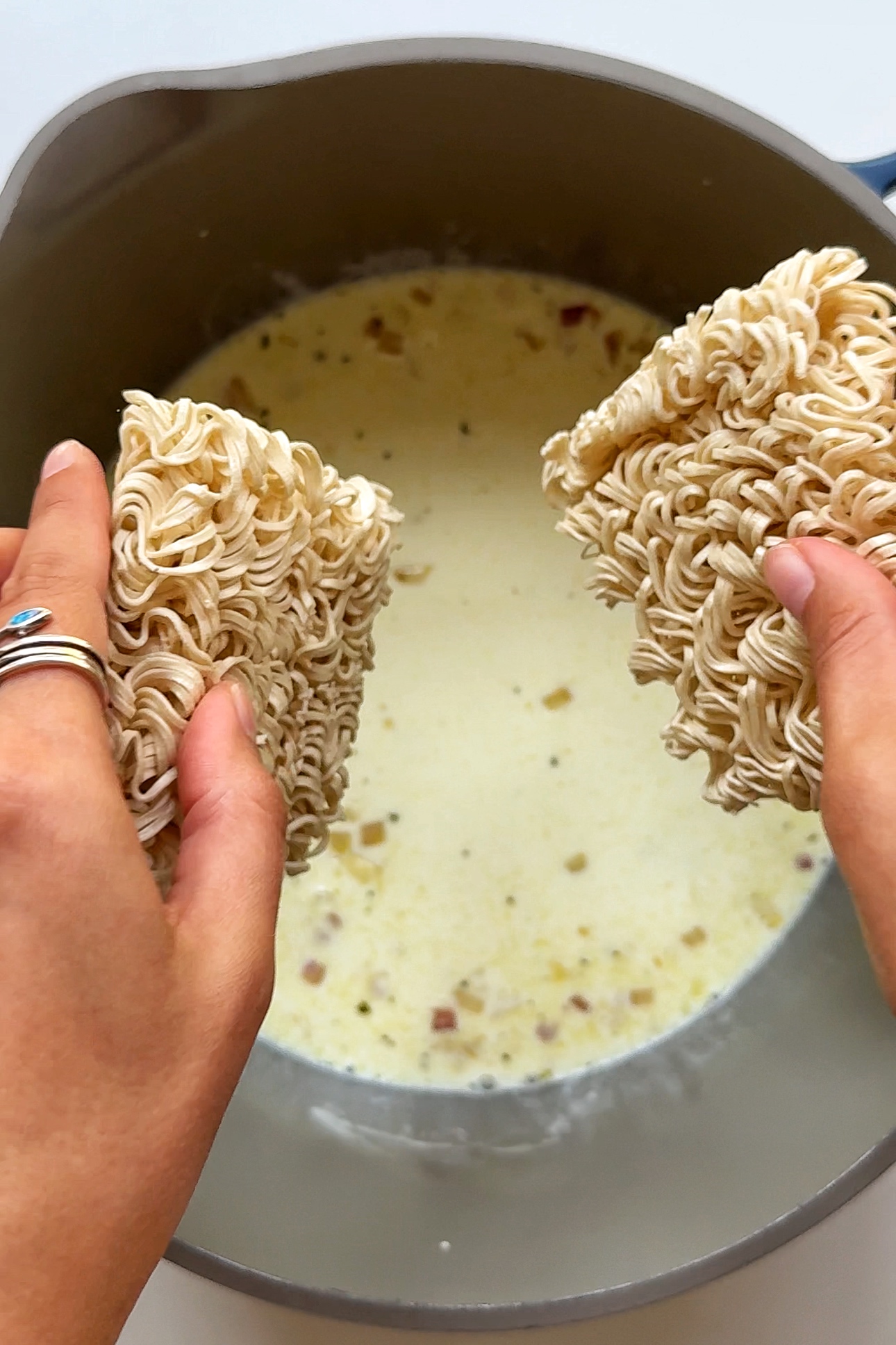 Adding noodles into our garlic parmesan sauce.