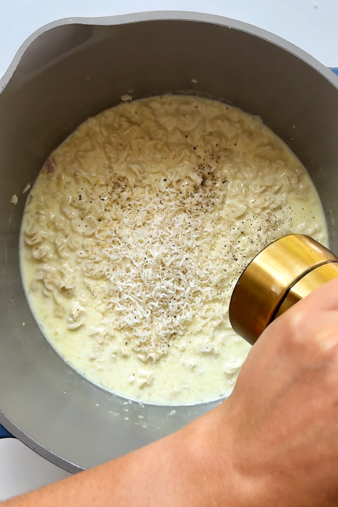 Adding black pepper into the garlic parmesan pan.