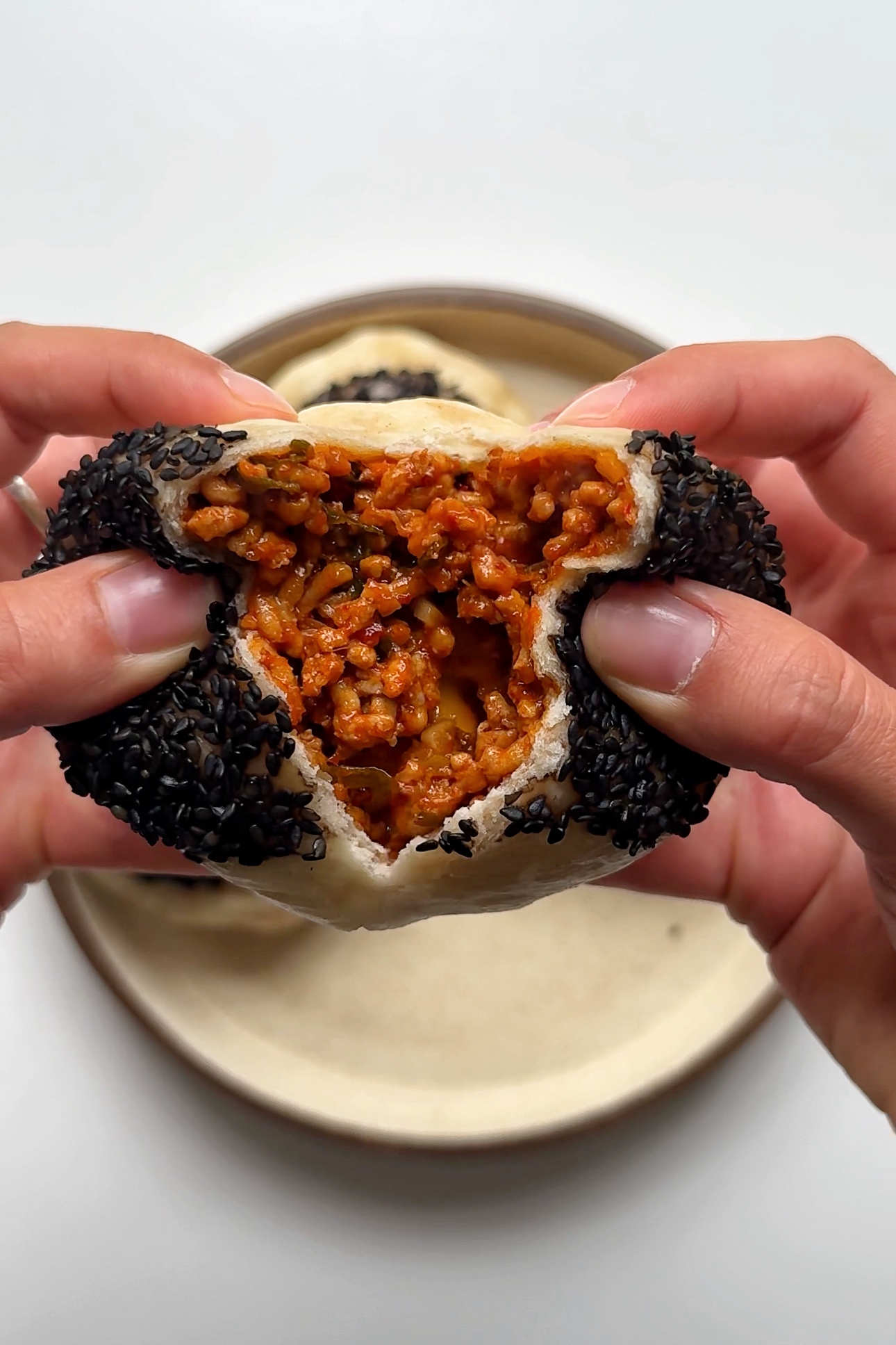 pulling apart gochujang pork steamed bun.