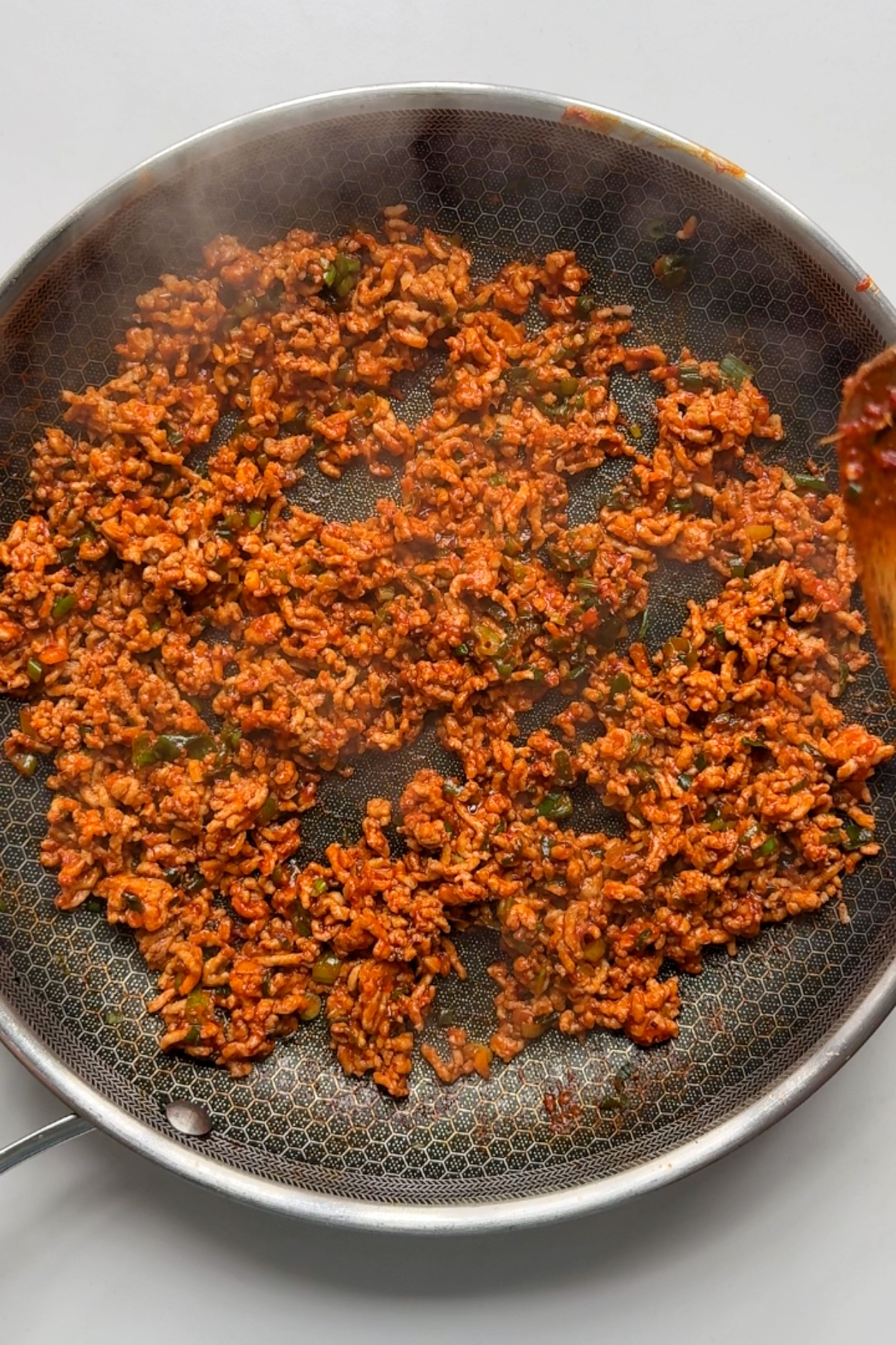 Adding gochujang into the dumpling filling pan.