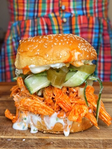 shredded buffalo chicken sandwich on wooden board.