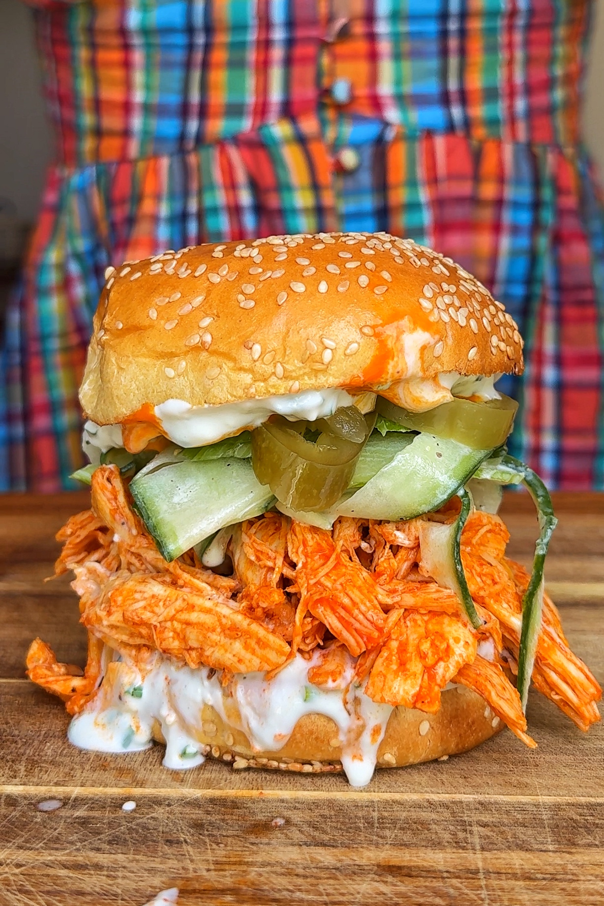shredded buffalo chicken sandwich on wooden board.