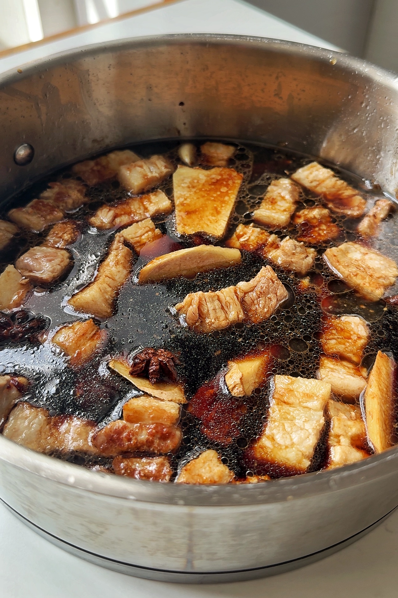 Simmering pork belly in liquid.