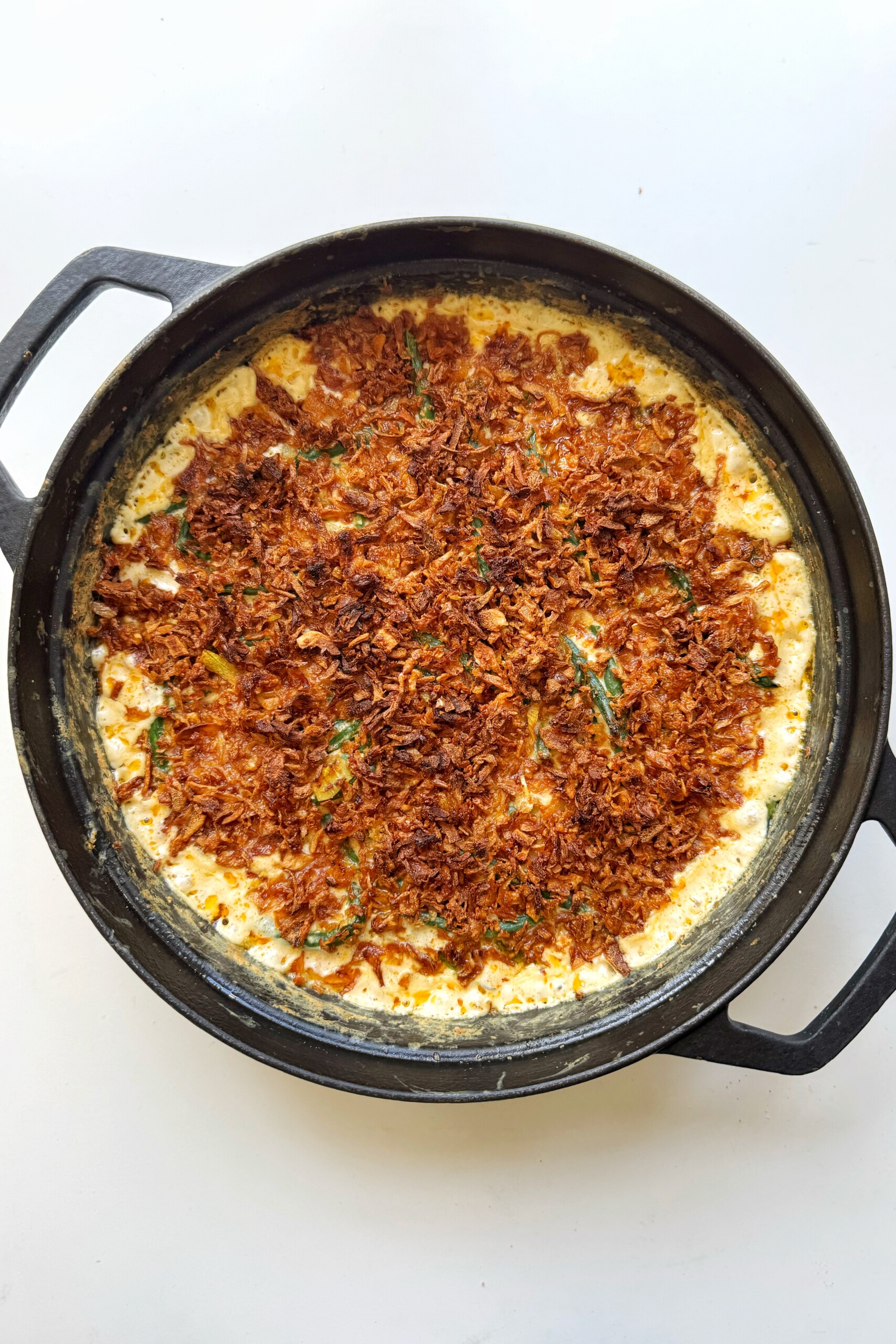 Green bean casserole in a black dish.