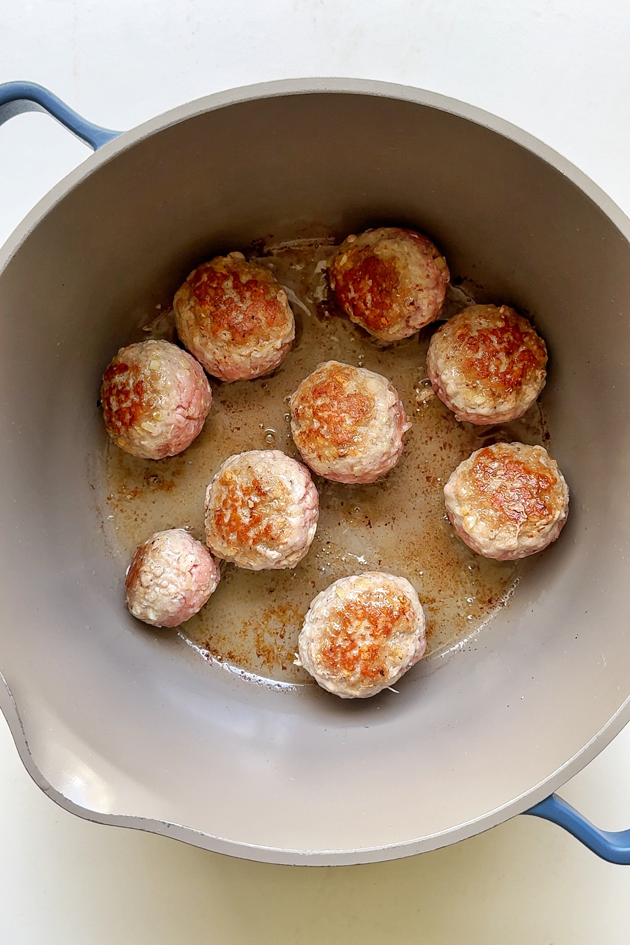 frying meatballs in a pan.
