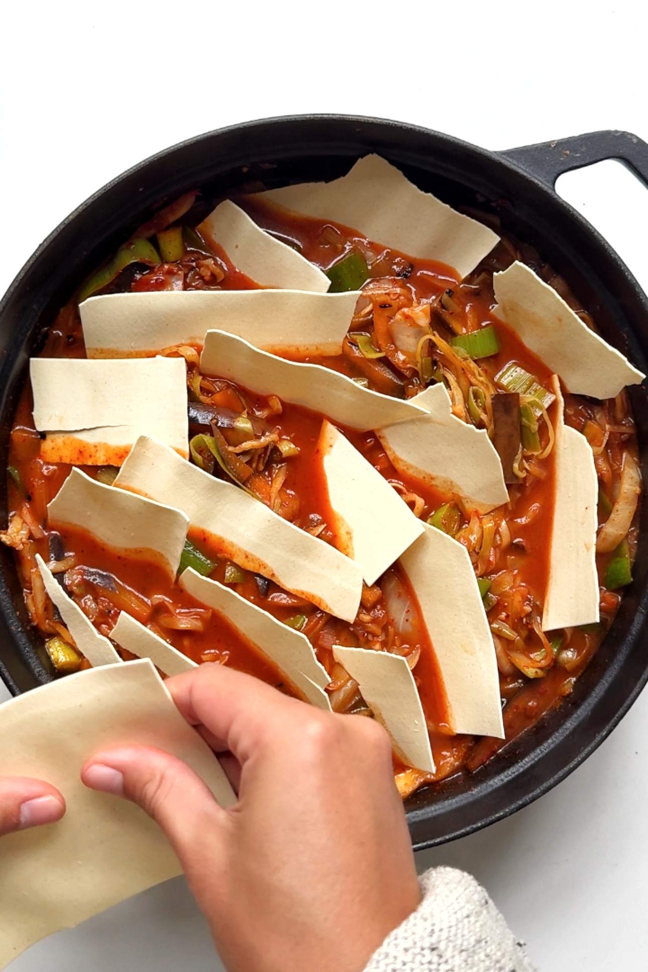 placing lasagne sheets in gochujang mixture.