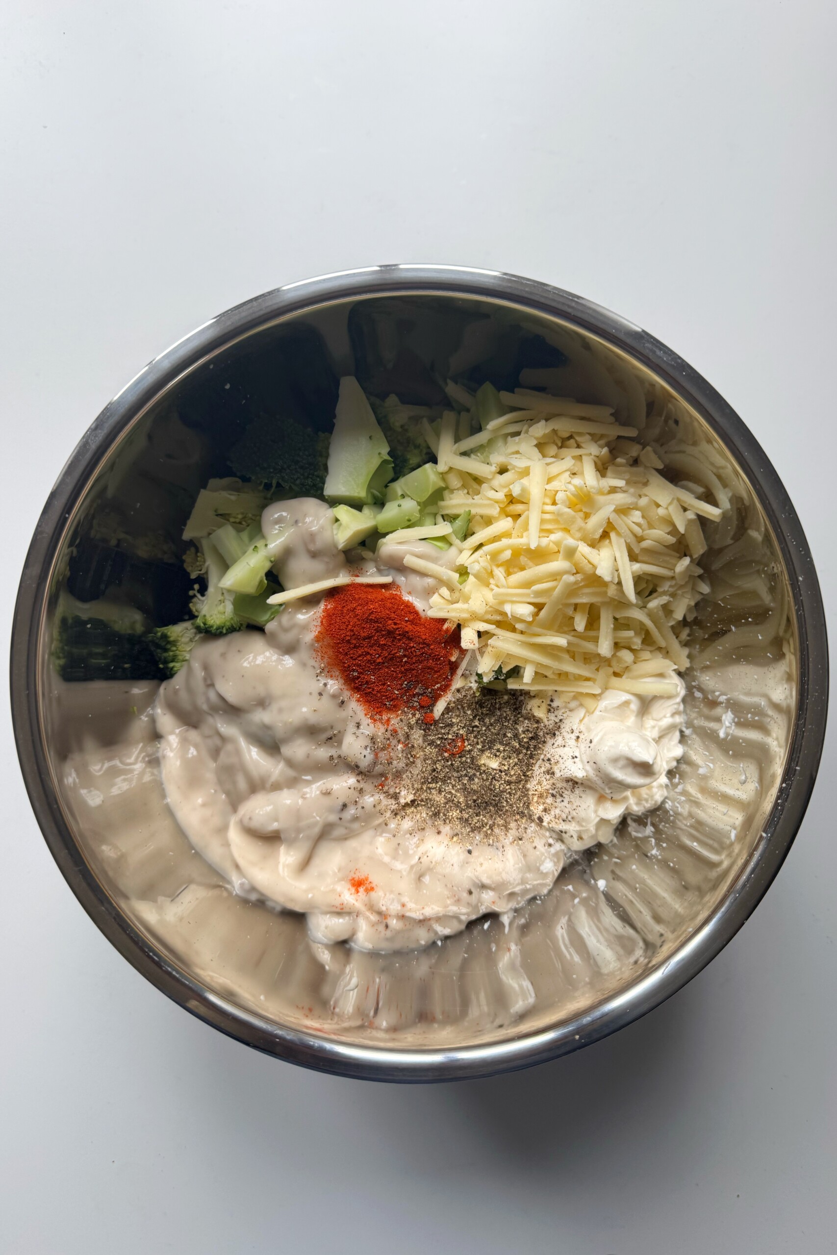 metal bowl with broccoli casserole ingredients inside.