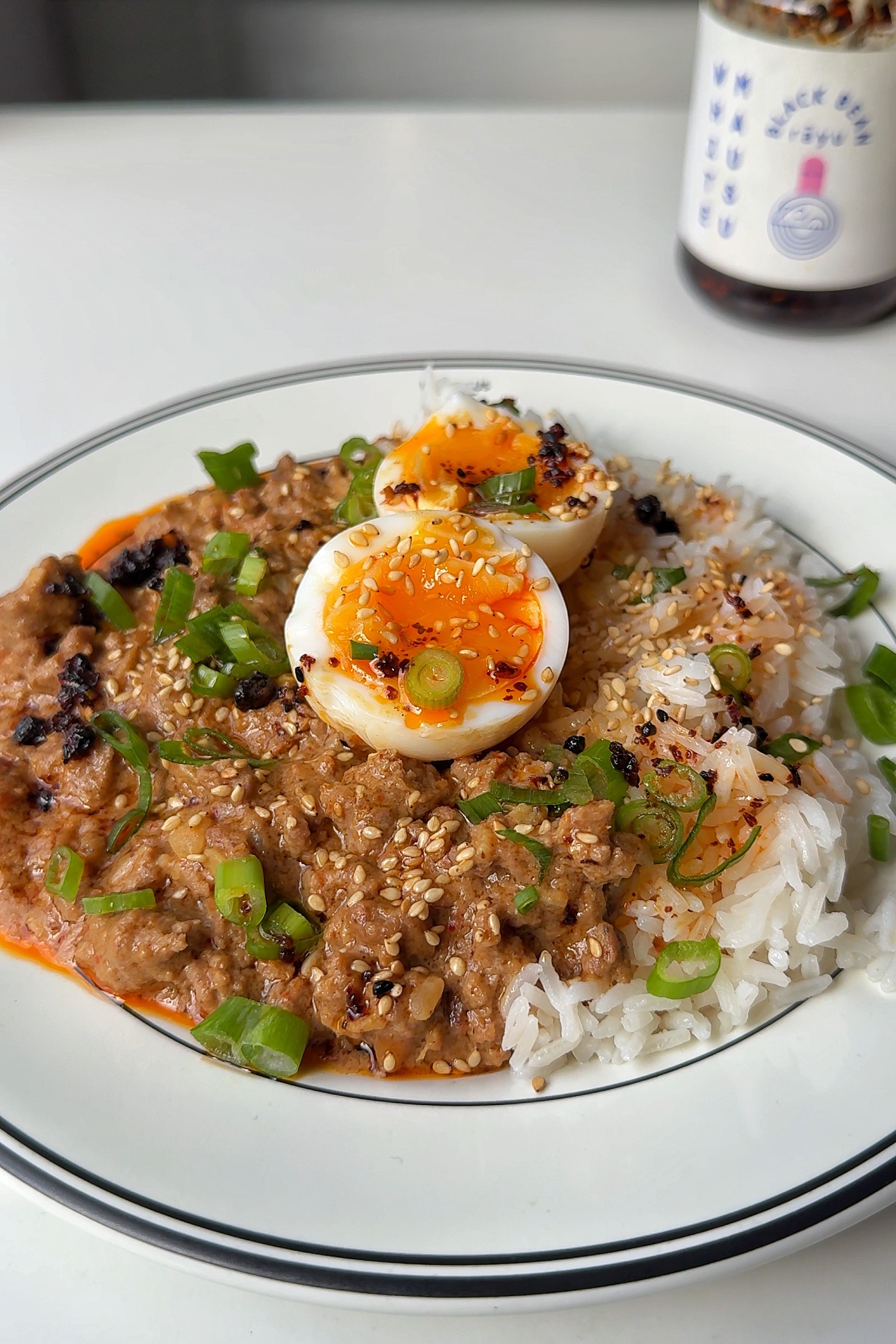 Bowl of spicy peanut butter ragu with jammy eggs.