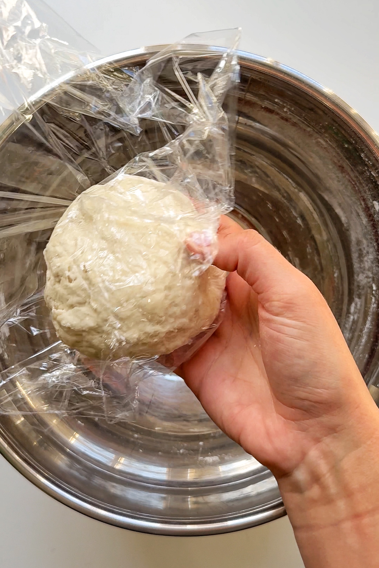 Wrapping ball of dough in clingfilm.