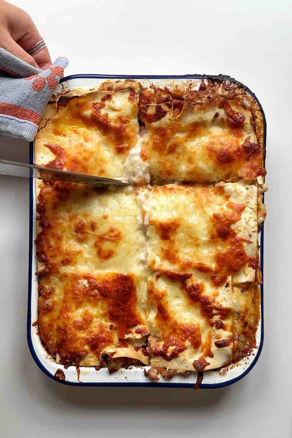 Serving up the lasagna in a tin tray.