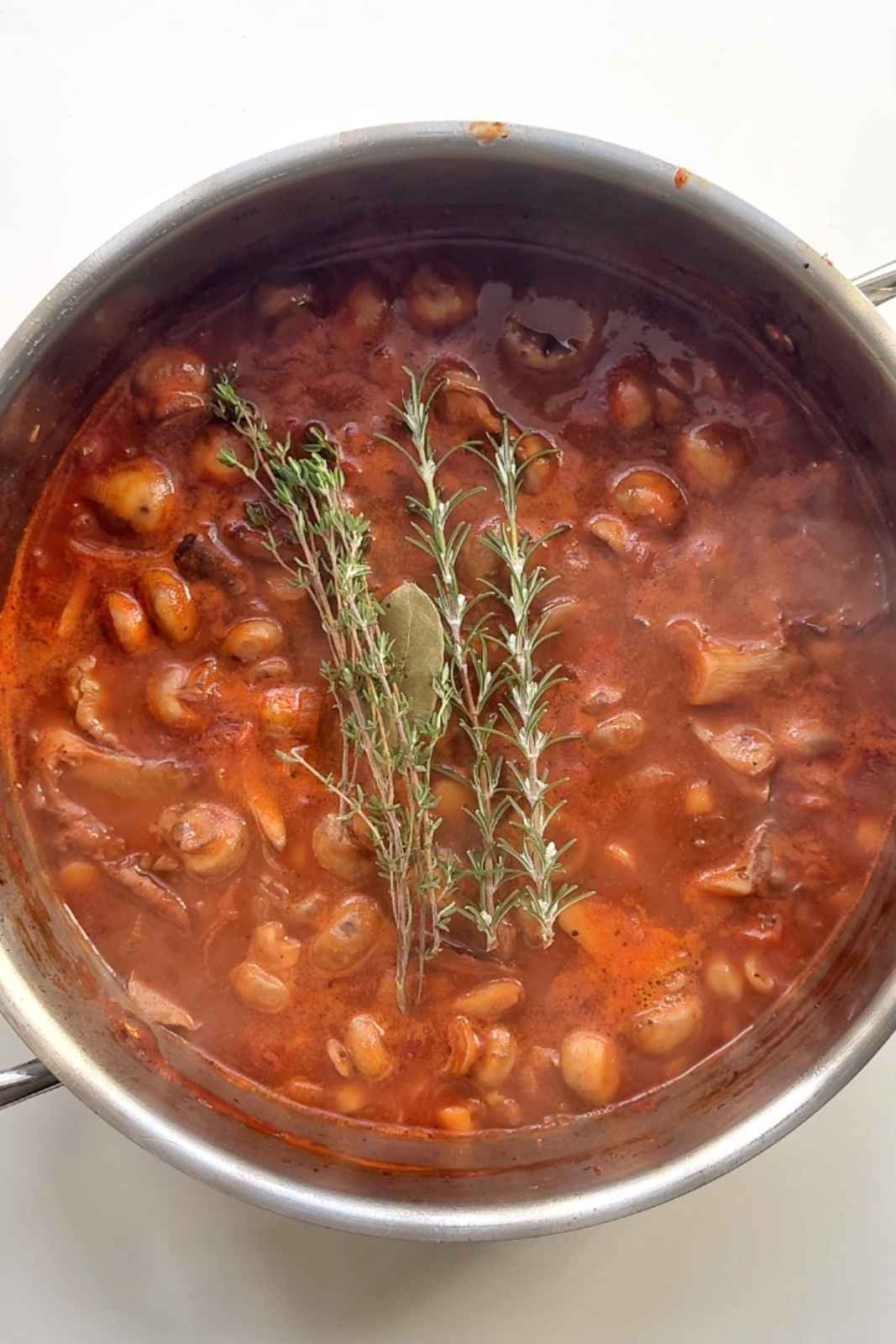 Adding herbs into the bourguignon pot.