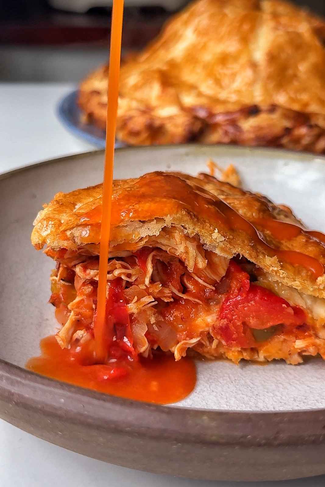 Pouring the chimichanga sauce over the pithivier.