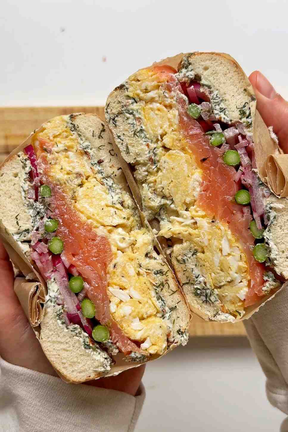 Cross-section of a smoked salmon bagel showing layers of cream cheese, egg, and salmon