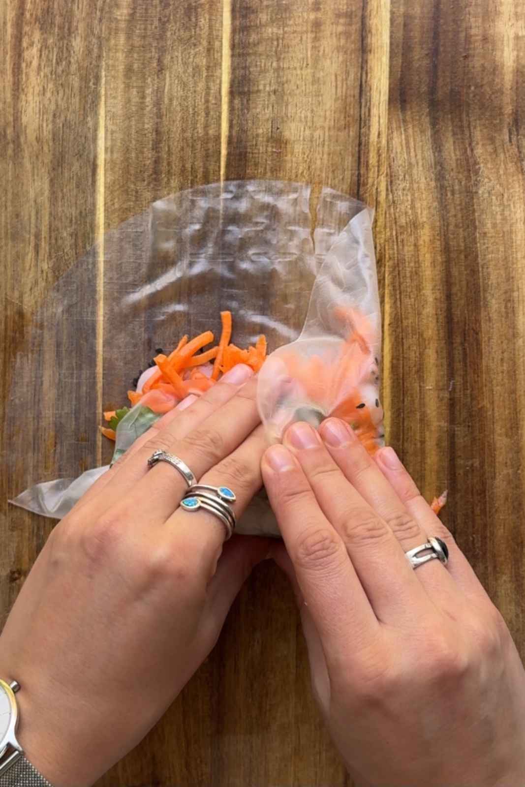 Folding in the side of summer rolls.
