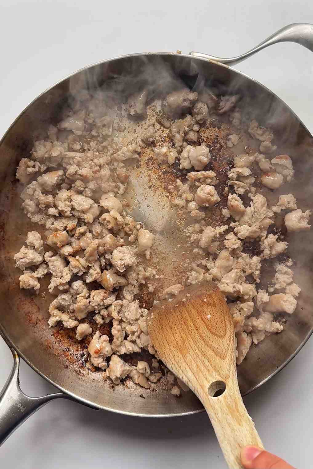 Frying sausage meat in a pan.