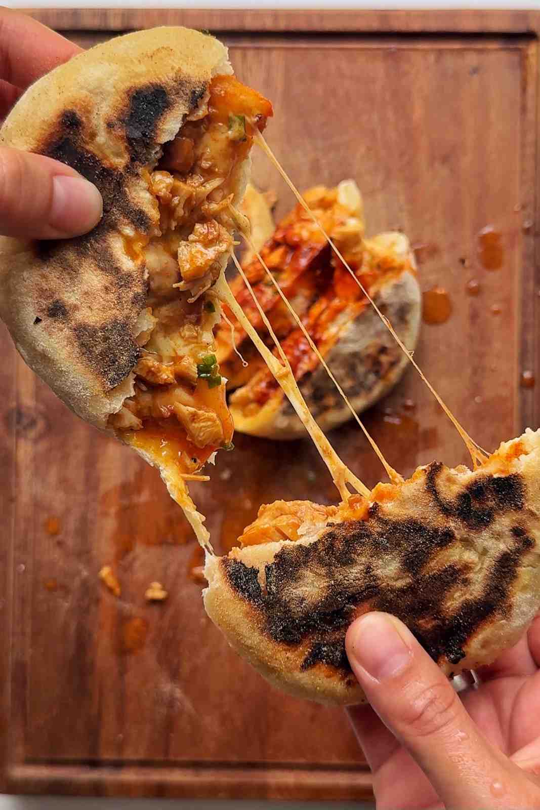 Pulling apart fire chicken stuffed flatbreads with a cheese pull.