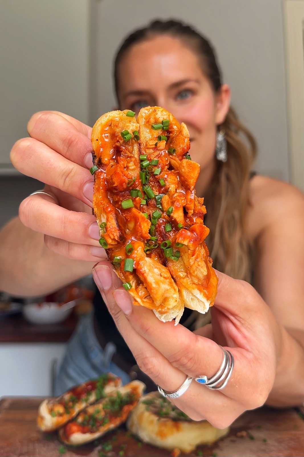 Emily Roz holding the fire chicken stuffed flatbreads to the camera.