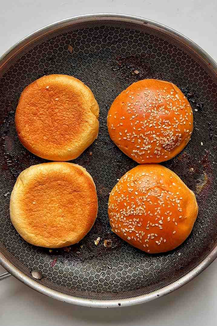 Burger buns frying in a pan.